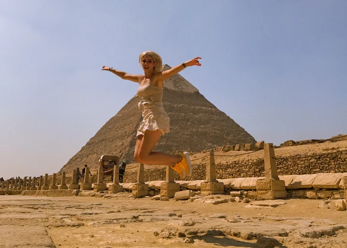 A picture of a visitor in front of the middle pyramid